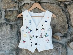 Me and my mom got together to start a new project to give a new life to good second hand clothes and hand embroider my illustrations on them. This is a 100% linen vest we up cycled and hand embroidered with an original illustrations made by me. This is a unique piece, 100% hand embroidered with love and care. Follow my shop to get notifications on new pieces that will come out! ⦁⦁ MAIN FEATURES ⦁⦁ Size: XS-S (EU size). Chest 43cm - 16.9in / Length 47cm - 18.5in / The fit is classic slim.  Materi Embroidered Vest, White Embroidered Summer Vest, White Embroidered Cotton Vest, Fitted Embroidered Cotton Vest, Multicolor Embroidered Sleeveless Cotton Vest, Embroidered Multicolor Cotton Vest, Multicolor Embroidered Cotton Vest, Folk Style Embroidered Vest, Vintage Embroidered Festival Vest