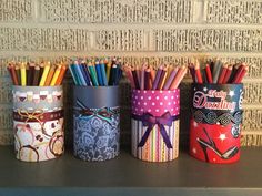 four colorful pencils are lined up on a shelf