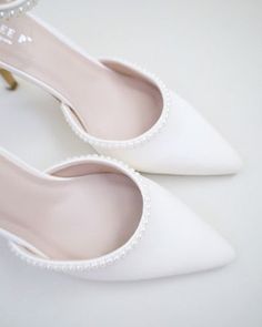 Classic satin pointy toe heels with an added touch for romantic, elegant and feminine look. The prettiest pearl details on this elegant satin heel checks off all the right boxes. The delicate mini pearl beads are placed carefully by hand to create a graceful classic bridal shoe. Perfect for brides, bridal party, bridesmaids, prom, parties, or any special occasion. DETAILS: HEELS: 3 inches COLORS AVAILABLE: Ivory and White UPPER: Synthetic upper and lining MATERIALS: Manmade outsole ORIGIN: Imported STYLE NAME: BELL Pearl Wedding Heels Bride Shoes, Pearl Wedding Heels, Wedding Heels Brides, Formal Heels, Bridal Shoe, Pearls Wedding, White High Heels, Pointy Toe Heels, Pearl Details