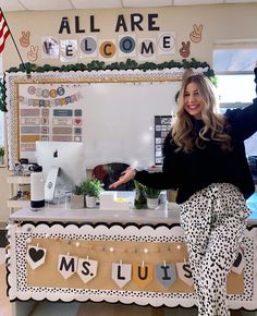 a woman standing in front of a welcome sign