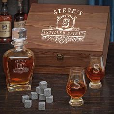 two glasses and an empty bottle sitting next to each other on a wooden box with the name stevens's printed on it