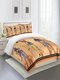 a bed with an egyptian theme on the comforter and pillow cases in a bedroom