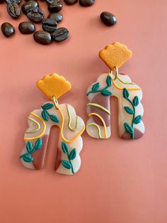 two decorated cookies sitting next to coffee beans