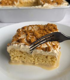 a piece of cake on a white plate with a fork in it and a casserole dish to the side