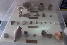 an assortment of ancient artifacts on display in a glass case