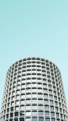 a very tall building with many windows on it's sides and the sky in the background