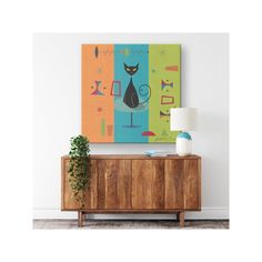 a painting hangs on the wall next to a wooden cabinet with a lamp and potted plant