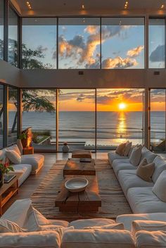 a living room filled with white couches next to a large window covered in lots of windows