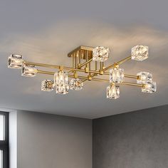 a chandelier that is hanging from the ceiling in a room with gray walls