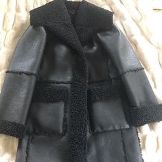 Elie Tahari Black Faux Leather Coat Has Shearling Detailed Seams, Patch Pockets, And Collar. Never Worn Smoke Free And Pet Free Home Black Long Coat With Faux Fur Lining, Black Faux Fur Coat For Workwear, Black Faux Fur Coat For Work, Chic Black Fur Coat For Work, Black Faux Fur Outerwear For Work, Chic Black Outerwear With Faux Fur Lining, Black Fur Coat For Winter Workwear, Black Luxury Faux Fur Outerwear, Faux Leather Coat