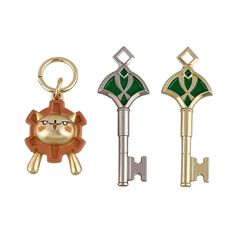 three keychains with different designs and colors on them, one in the shape of a lion