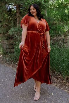 a woman in a red dress standing on the road