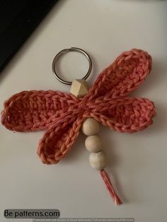 a crocheted keychain with beads attached to it and a ring on the end