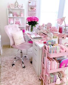 a pink desk and chair with lots of stuff on it in a room filled with furniture