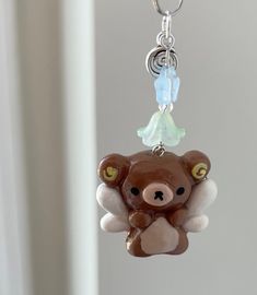 a brown teddy bear with angel wings hanging from a key chain