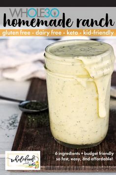 a jar filled with homemade ranch dressing on top of a cutting board