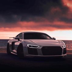 an audi car parked on the beach at sunset