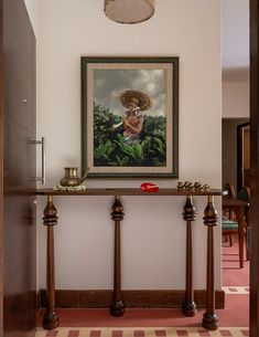 a painting hangs on the wall above a console table