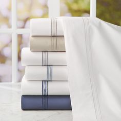 a stack of white and blue sheets on top of a table