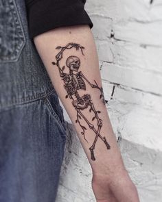 a person with a skeleton tattoo on their arm