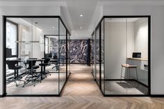 an office with glass walls and wooden floors