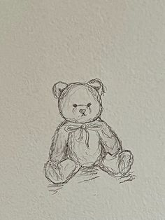 a drawing of a teddy bear sitting on the floor in front of a white wall