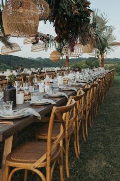 a long table set up with plates and place settings for an outdoor dinner party in the countryside