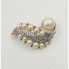 This is part of Chairish’s Costume Jewelry assortment.  1950s rhodium plated faux-pearl and clear rhinestone brooch. Marked "Jomaz." Measures: 2 inches wide by 1 1/2 inches long. Excellent condition.   Please reference the measurements noted in the description above for the best approximate dimensions. Please reach out to the seller under "Ask the Seller" for specific questions regarding the measurements. Formal Silver Pearl Brooch, Rhinestone Brooches, Clear Rhinestones, Vintage 1950s, Rhodium Plated, Costume Jewelry, Faux Pearl, Plating