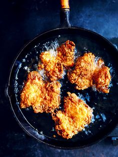 fried chicken is cooking in a frying pan