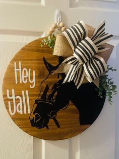 a wooden sign that says hey y'all with a horse and bow on it