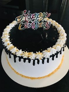 a birthday cake with white frosting and black icing that says happy birthday on top