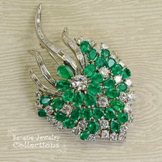 Stunning burst of vivid green emeralds and sparkly white diamonds covering all the surfaces of this beautiful platinum vintage brooch! Total Weight: 29.15 grams Size: 2.5 inch tall, 1.5 inch wide Precious Metal: Platinum Precious stones: -Emeralds: QTY: 31, 2.7mmx4.7mm to 4.2mmx6.3mm size, 7.5 carats -Diamonds: 29 rounds, 20 baguettes, 6 carats Elegant Green Diamond Brooch, Vintage Green Diamond Brooches, Luxury Green Brooch For Anniversary, Luxury Green Brooches For Anniversary, Green Diamond Wedding Brooches, Green Fine Jewelry Brooches For Wedding, Luxury Green Brooches For Wedding, Fine Jewelry Green Brooch For Anniversary, Fine Jewelry Green Brooches For Anniversary