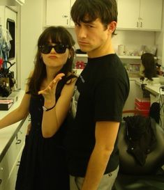 a man standing next to a woman wearing sunglasses