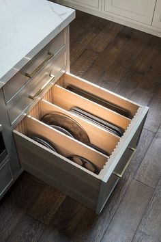 an open drawer in the middle of a kitchen