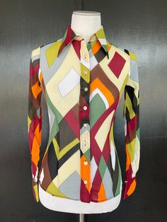 1970s Wayne Rogers blouse. Multicolor almost sheer crepe texture nylon. Nine button front. Two button cuffs. Size 7/8 Measurements  32" bust 24" midriff  30" hem 23" length 22" sleeves 13" shoulders There is a decent amount of stretch to this fabric. Lovely blouse shows beautifully with no wear.  Deadstock item with Bonwit Teller hangtag still attached. Spring Vintage Blouse With Colorful Pattern, Multicolor Collared Blouse With Colorful Pattern, Retro Long Sleeve Multicolor Print Top, Vintage Fitted Multicolor Print Tops, Retro Multicolor Print Long Sleeve Blouse, Long Sleeve Multicolor Retro Print Blouse, Multicolor Retro Print Long Sleeve Blouse, Fitted Vintage Multicolor Print Tops, Multicolor Long Sleeve Retro Print Blouse