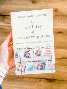 a person holding up a book about the mystery of ordinary places by shannan martin