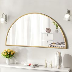 a white dresser topped with a mirror and vase filled with flowers