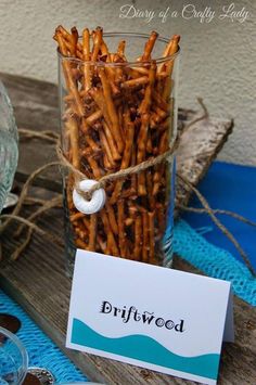 a jar filled with fries sitting on top of a wooden table next to a sign