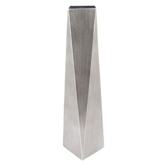 a tall metal vase sitting on top of a white table