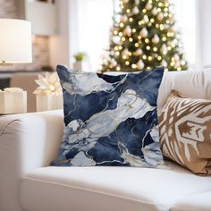 a living room with a white couch and christmas tree in the backgroung