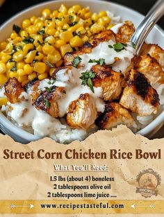 a bowl filled with chicken, rice and corn on top of a table next to a fork