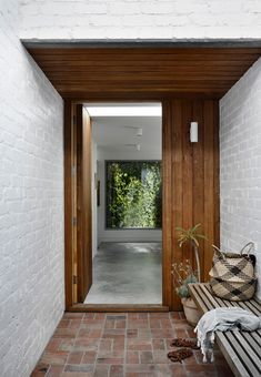 an entry way with a bench and potted plants