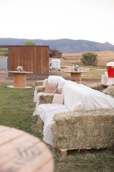 hay covered couches and tables in an outdoor setting