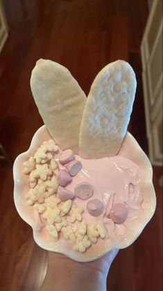 someone is holding up a bowl with marshmallows and candy in the shape of a bunny