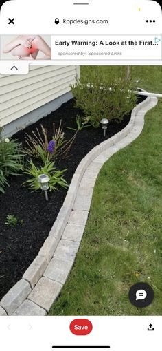 a small garden with flowers and plants in the grass next to a home's front yard