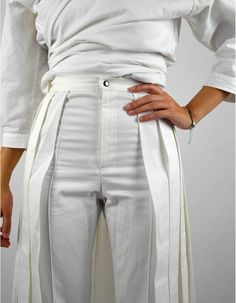 Made in FranceProduct description :- High-waisted straight white pants,- Without pockets, on which is added a pleated skirt open on the front,- Closed with a zip fly and a metal snap button.The clean lines and pleats of the Yaga Pant echo those of the Yaga Shirt. Made in white cotton twill from the end of rolls of fabric from a large luxury house, it will accompany your looks with delicacy and originality. The Yaga Pant will be the centerpiece of your outfit and will give you a strong and impact High-waisted Pleated Hem Bottoms For Work, High Waist Bottoms With Pleated Hem For Work, White Pleated Cotton Bottoms, Summer White Bottoms With Pleated Hem, White Bottoms With Accordion Pleats For Summer, White Pleated Summer Pants, White Pleated Hem Bottoms For Spring, Spring White Bottoms With Pleated Hem, Summer White Pleated Pants