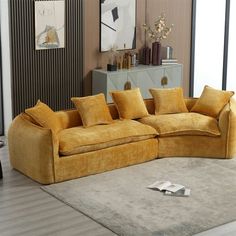 a yellow couch sitting on top of a rug in a living room