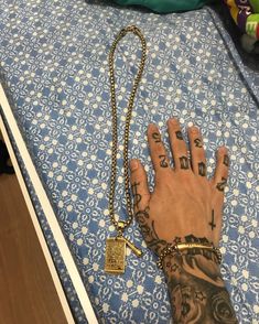 a person's hand with tattoos on it and a chain attached to the wrist