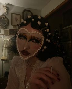 a woman with makeup and pearls on her face