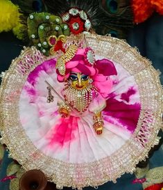 a close up of a person in costume on a plate with feathers and beads around it